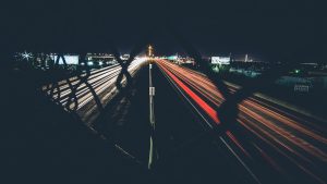 Long-exposure light trails from cars on a highway at night